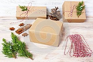 Creative hobby. Gift wrapping. Packaging modern christmas present boxes in stylish gray paper with satin red ribbon. Top