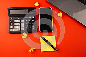 Creative home workplace with black pen, clcok and yellow sticky note on red background. Work from home concept