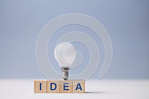 Creative idea generation. Creativity and innovation. Originative thinking. Wooden cubes, idea inscription and lightbulb