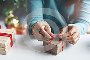 Creative ideas handmade gift for holidays. boxes woman tying red bow decorated the craft presents box prepare for christmas.