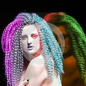 Creative Ideas. Portrait of Sensual Caucasian Girl With Frizzy Colorful Hair and Artistic Eyes Makeup. Mixed Light Used