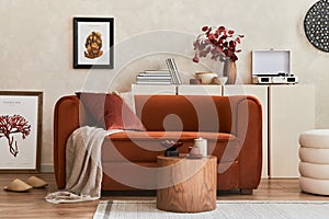 Creative interior composition of living room with mock up poster frame, designed couch, coffee table, vintage record-player, pouf.