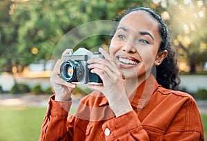 Creative juices flowing. a young woman holding her camera while standing outside.