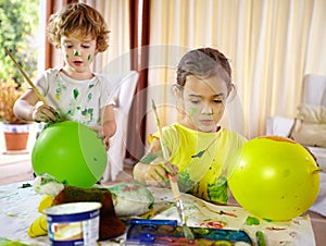 Creative kids. a brother and sister making a mess painting at home.