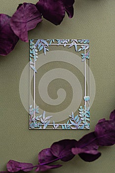 Creative layout with blank transparent acrylic card certificate with green leaves on eco green background with purple red leaves. photo