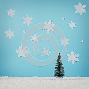 Creative layout with Christmas tree and snowflakes on bright blue background