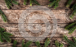 Creative layout frame made of Christmas fir branches, pine cones on wooden background.