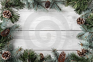 Creative layout frame made of Christmas tree branches and pine cones on white background. Xmas and New Year theme.