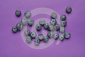 Creative layout made of blueberry on violet background