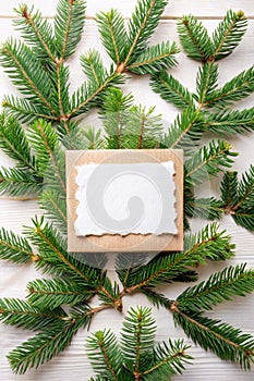 Creative layout made of Christmas tree branches with paper card note. Flat lay. Nature New Year concept