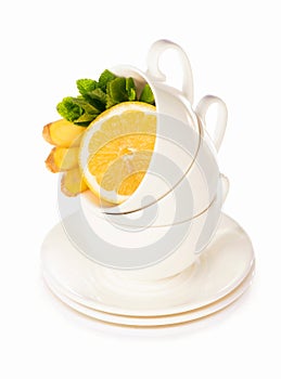 Creative layout made of cup of mint tea, lemon, ginger on a white background