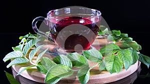 Creative layout made of cup of red tea and tea leafs. Tea time: cup of tea, carcade, karkade, rooibos. Oriental, cozy, ceremony,