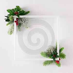 Creative layout made of fir branches with Christmas decorations and frame on white background.