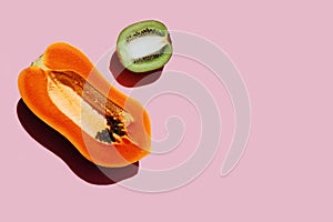 Creative layout made of papaya and kiwi fruit with stainless kitchen knives.