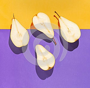 Creative layout made of raw sliced pears on bright violet and orange geometric background with shadow. Minimal style. Healthy food