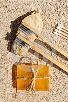 Creative layout made of two toothbrushes, natural soap and cootton buds on sunlit background with towels. Morning routine concept