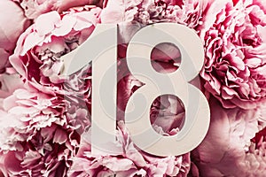 Creative layout. Peony flowers, digit eighteen. Birthday greeting card with inscription 18. Anniversary concept. Top view. Copy