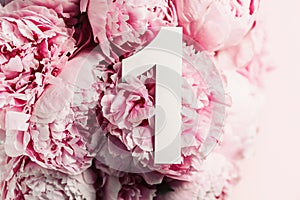 Creative layout. Pink peony flowers and digit one 1. Birthday greeting card. Anniversary concept. Top view. Copy space. Stylish