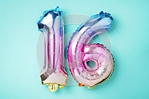 Creative layout. Rainbow foil balloon number, digit sixteen. Birthday greeting card with inscription 16. Anniversary