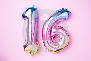 Creative layout. Rainbow foil balloon number, digit sixteen. Birthday greeting card with inscription 16. Anniversary