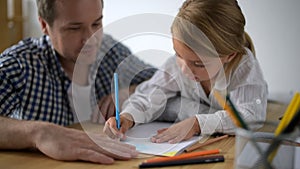 Creative little girl drawing with her father at home