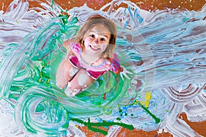 Creative little girl having fun with paint