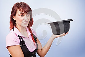 Creative magician woman holding a surprise hat