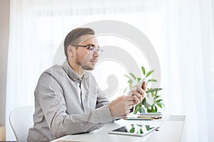 Creative male office worker texting on smarphone