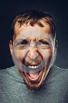Creative male portrait. Young handsome man is screaming. Radical expression and emotion concept photo
