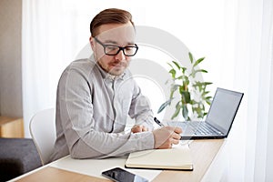 Creative man or businessman writing to notebook