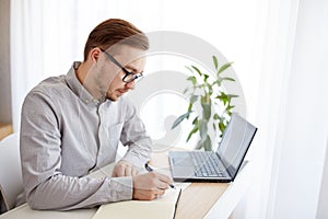 Creative man or businessman writing to notebook