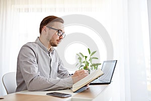 Creative man or businessman writing to notebook