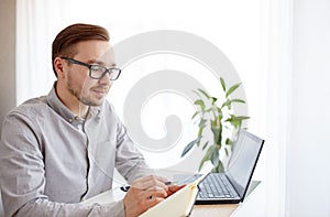 Creative man or businessman writing to notebook