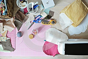 Creative mess: fabric scraps, thread, scissors, rotary cutter, sewing supplies, cutting mat, quilting clips, needles, pincushion,