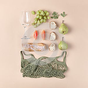 Creative minimal picnic flat lay. Reusable and eco friendly food layout. Wine glass, fruit and bread grocery