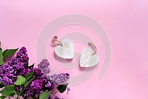 Creative minimalist banner with lilac flowers and white wood rustic heart on trendy pink background. Web banner. Top