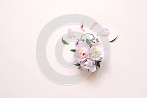 Creative minimalistic composition with a Clock. Alarm clock with peony flowers. Spring time. Time to love. Top view