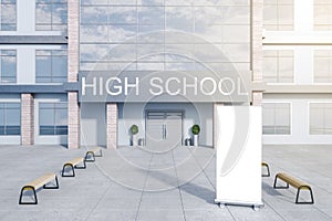 Creative modern high school building exterior with empty white mock up poster stand, benches, glass with reflections and daylight