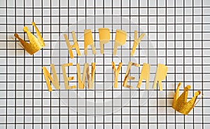Creative New Years background with golden text Happy New Year on minimalistic white and black checkered backdrop