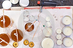 Creative occupation of candle making showing the pouring of liquid wax into jars