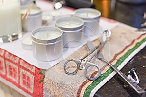 Creative occupation of candle making showing the pouring of liquid wax into jars