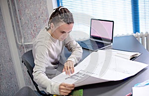 Creative office work, young man looks papers