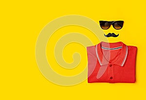 Creative party decoration concept. Black mustache Sunglasses red polo shirt props for photo booths carnival parties on yellow