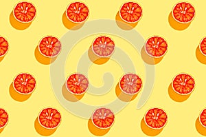 Creative pattern made with half of blood orange on bright yellow background. Summer fruit and vitamin concept. Minimal style. Top