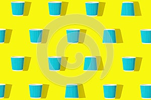 Creative pattern made of paper cups of coffee or tea to go on bright yellow background. Eco friendly concept. Flat lay. Top