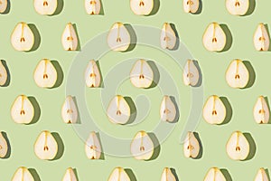 Creative pattern made of raw sliced pears on green pastel background with shadows. Minimal style. Healthy food ingredient concept