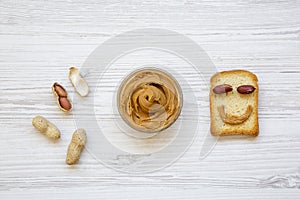 Creative pattern made of toast, peanut butter and peanuts in shells, top view.