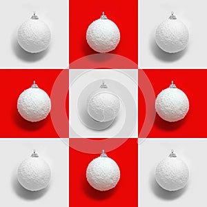 Creative pattern with white New years balls, holiday toys on red and blue. Christmas greeting card