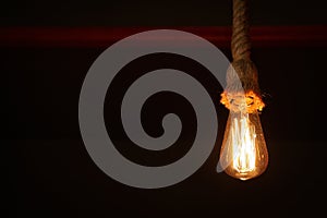 Creative pendant lamp in dark room, closeup. Space for text