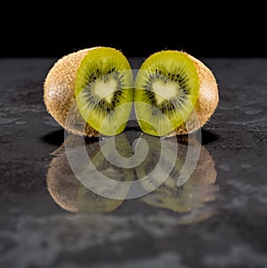 Creative pictures of fresh kiwis on slate and black background